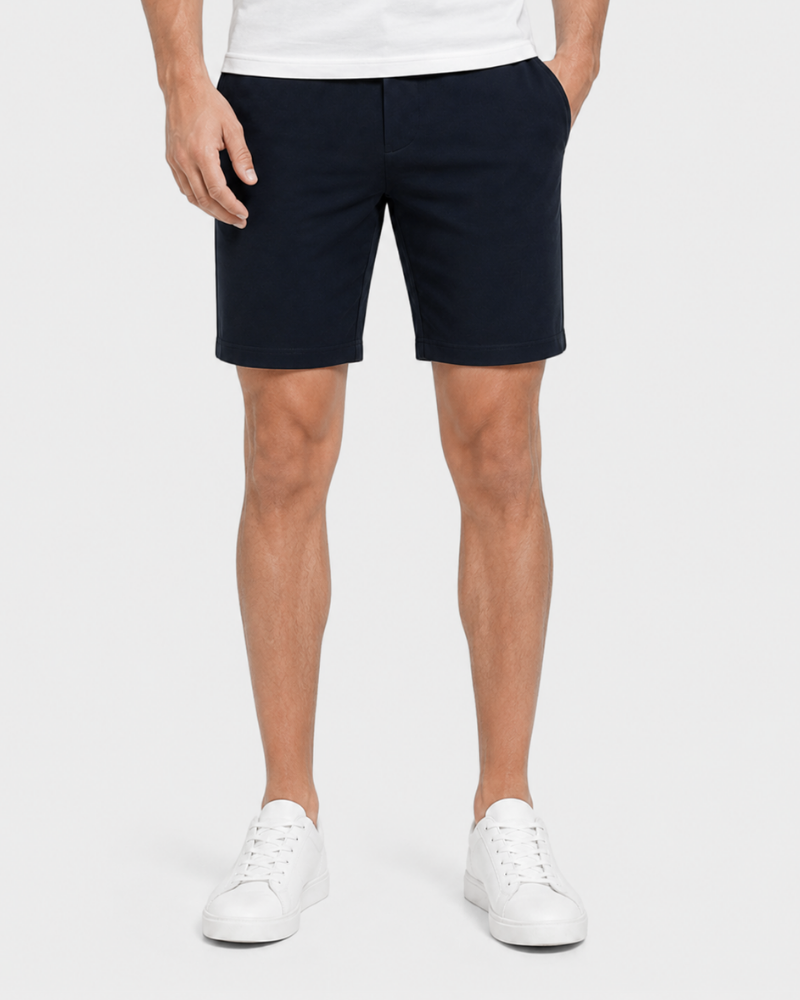 Person wearing Grant Oak navy chino shorts and white sneakers on a light gray background #Color_navy