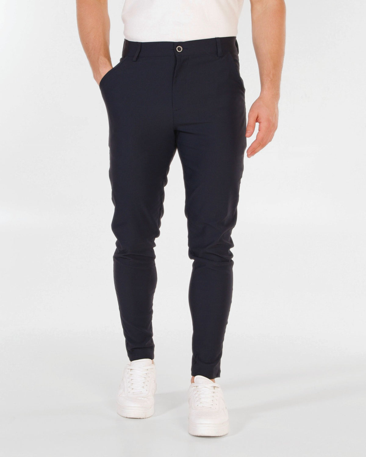 Grant Oak Smart Fit Chinos 2-Pack Black & Navy — slim-fit dark navy chinos with a white t-shirt and white sneakers, shown from the waist down against a light gray studio background.