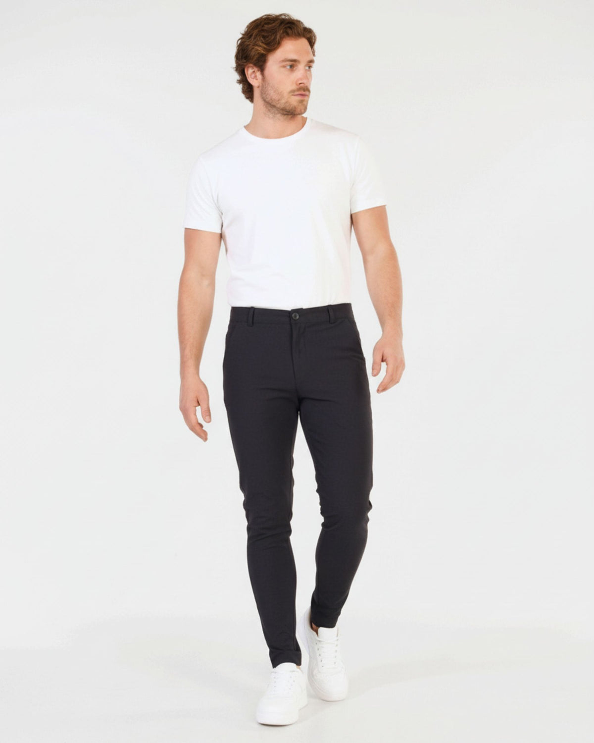 Grant Oak Smart Fit Chinos 2-Pack Navy & Dark Gray — man wearing a white crew-neck t-shirt and slim-fit dark gray chinos with white sneakers against a solid white studio background.