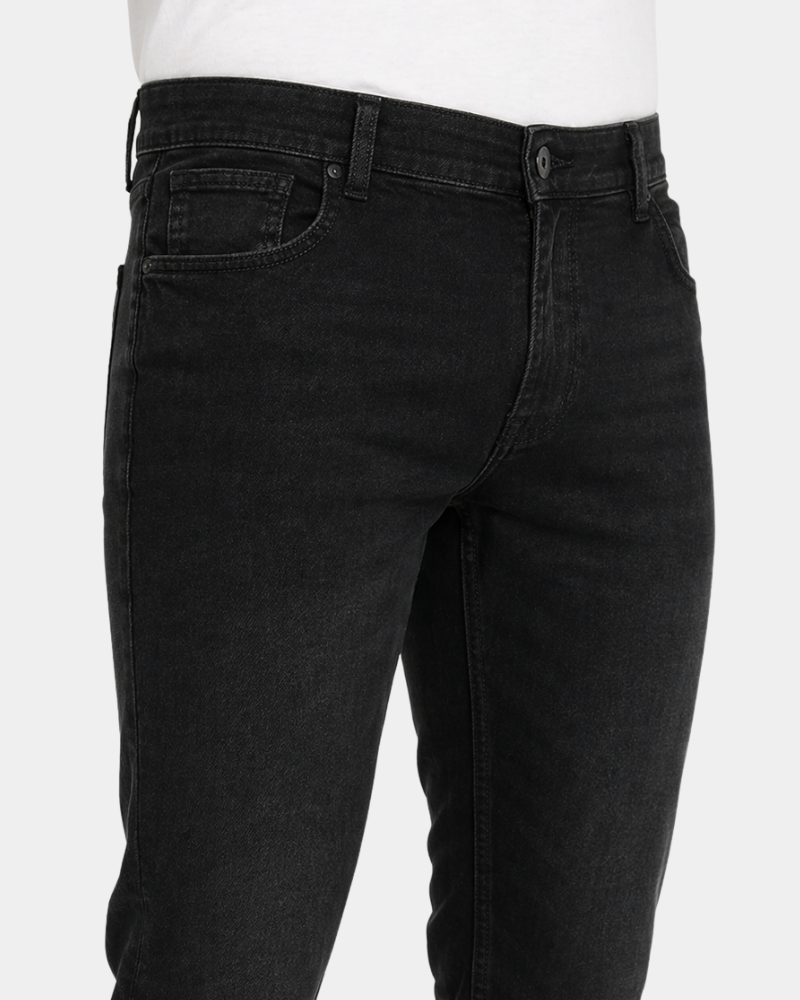 Grant Oak black slim fit jeans worn by a male model, close-up front angle view of waistband and pocket detail, light grey background #Color_black