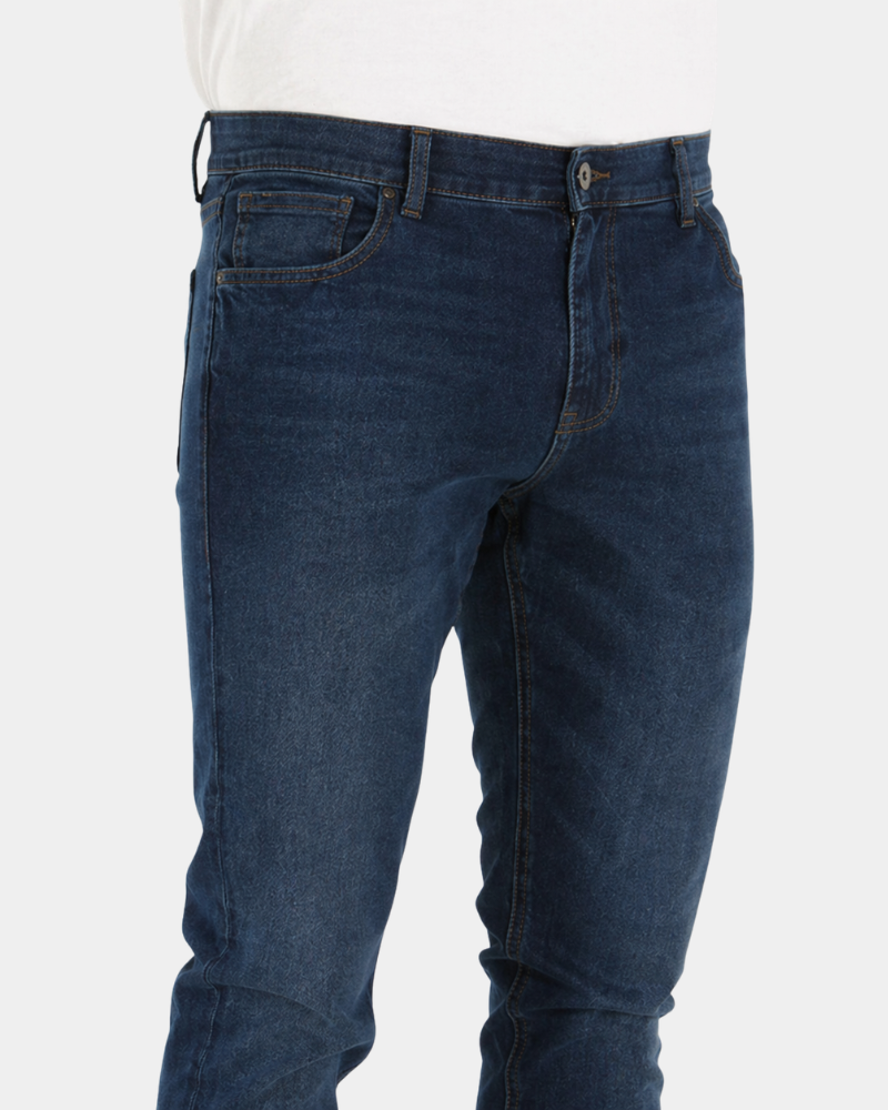 Grant Oak navy slim fit jeans worn by a male model, close-up front angle view of waistband and pocket detail, light grey background #Color_navy